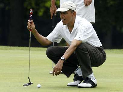President Barack Obama lines up a putt on the first green at Andrews Air Force Base in Maryland, June 18, 2011. Foto: Larry Downing / Reuters In English