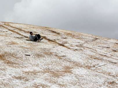 Un joven se desliza por una colina tras una inusual nevada en Johannesburgo, el martes 7 de agosto del 2012.  Foto: Themba Hadebe / AP