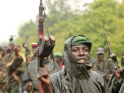 M23 rebel fighters celebrate in the rain at Rumangabo after government troops abandoned the town 23 km (14 miles) north of the eastern Congolese city of Goma, July 28, 2012. Foto: James Akena / Reuters In English