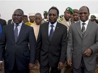 Mali's interim President Diouncounda Traore (C), flanked by Burkina Faso's Foreign Minister Djibril Bassole (R) and Ivory Coast's Minister of African Integration Adama Bictogo, arrives at Bamako airport after Mali's military junta agreed to hand over power to a civilian government led by Traore April 7, 2012. Foto: Joe Penney / Reuters In English