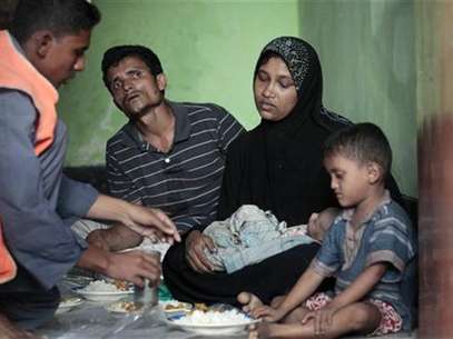 A member of the Bangladesh Coast Guard serves food to Mohammad Rafique and Amena Akter, both Rohingyas from Myanmar, in Teknaf June 19, 2012. Foto: Andrew Biraj / Reuters In English