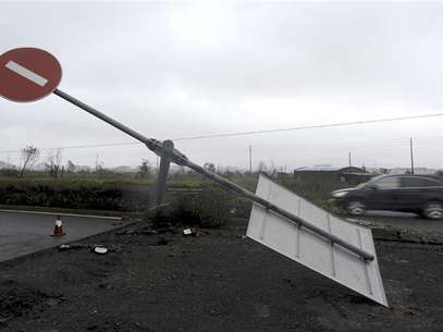 A car drives past a damaged traffic sign as Typhoon Haikui hits Hepu township, Zhejiang province, August 8, 2012. Foto: Lang Lang / Reuters In English