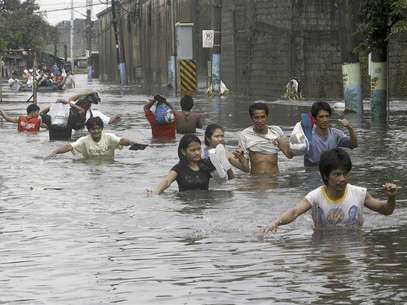 Residents wades through floodwaters on a submerged main street in Valenzuela, north of Manila August 8, 2012. Foto: Romeo Ranoco / Reuters In English