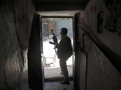 A Free Syrian Army fighter holds his gun as he looks at a street from a house during clashes with Syrian Army in the Salaheddine neighbourhood of central Aleppo August 7, 2012. Foto: Goran Tomasevic / Reuters In English