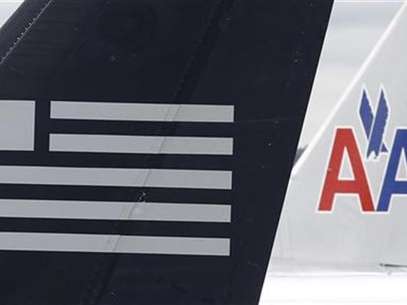 A US Airways plane and an American Airlines plane share a terminal at Ronald Reagan National Airport in Washington April 23, 2012. Foto: Kevin Lamarque / Reuters In English