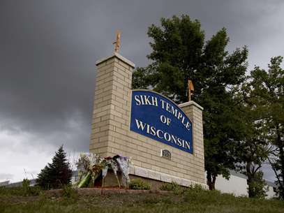 Unas flores reposan en la señal del templo sij de Wisconsin donde el 5 de agosto un hombre comenzó a disparar y mató a seis personas, el jueves 9 de agosto de 2012.  Foto: Jeffrey Phelps / AP