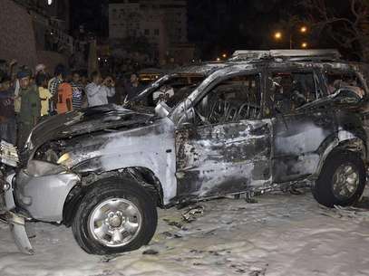 People look at the burnt car of Brigadier Omar Salim Ba-Rashid, the dean of the Military Academy, after a blast ripped through it in the southern Yemeni port city of Mukalla August 9, 2012. Foto: Stringer / Reuters In English