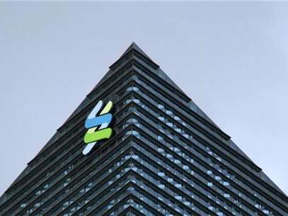 The logo of Standard Chartered is seen at its new Singapore office tower at the Marina Bay Financial Centre, January 24, 2011. Foto: Kevin Lam / Reuters In English