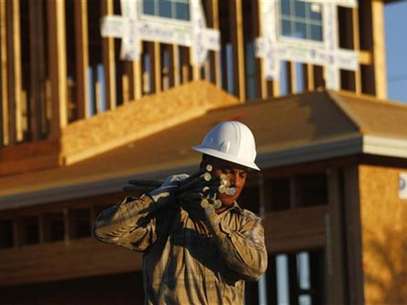 A worker carries materials for a house being constructed in Phoenix, Arizona, August 23, 2011. Foto: Joshua Lott / Reuters In English