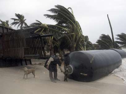 Un hombre inspecciona una defensa marina que fue arrastrada a tierra después de haber sido arrancada de los muelles al paso del huracán Ernesto por Majahual, cerca de Chetumal, México, el miércoles 8 de agosto de 2012.  Foto: Israel Leal / AP