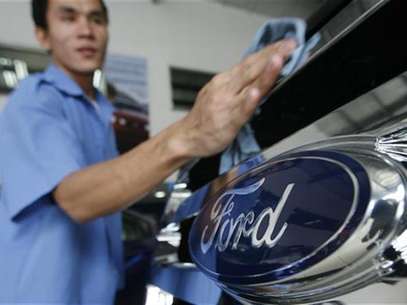 A worker waxes a car in a Ford automobile showroom in Manila June 28, 2012. . Foto: Cheryl Ravelo / Reuters In English