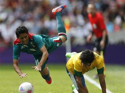 Mexico's Javier Aquino (L) falls over Brazil's Rafael during their men's football gold medal match at Wembley Stadium during the London 2012 Olympic Games August 11, 2012. Foto: Sergio Moraes / Reuters In English