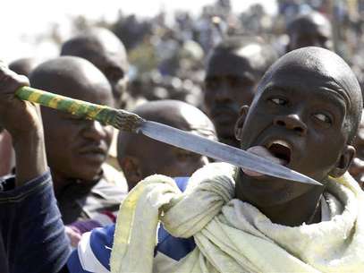 A protester licks his spear outside a South African mine in Rustenburg, 100 km (62 miles) northwest of Johannesburg, August 16, 2012. Foto: Siphiwe Sibeko / Reuters In English