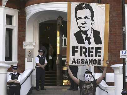 A protestor holds a poster of Wikileaks founder Julian Assange outside Ecuador's embassy in London August 17, 2012. Foto: Neil Hall / Reuters In English