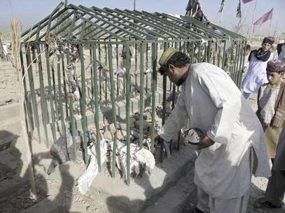 Un hombre recoge algunas pertenencias de las víctimas en el lugar donde estalló una bomba en un cementerio en Lashkar Gah, al suroeste de Kabul, Afganistán, el domingo 19 de agosto de 2012. Dos hermanos de un legislador perecieron en el atentado. Otros siete integrantes de la familia que visitaba una tumba resultaron heridos en el cementerio, dijo la policía.  Foto: Abdul Khaleq / AP