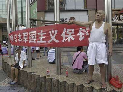 A protester (R) yells anti-Japan slogans as he holds a stick in front of a banner on a commercial street in Wuhan, Hubei province August 18, 2012. Foto: Stringer / Reuters In English