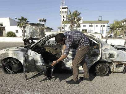 A military personnel examines a car, which exploded near a women's police academy, in Tripoli August 19, 2012. Foto: Ismail Zitouny / Reuters In English