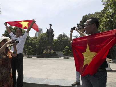 A woman takes a photo of bloggers attending an anti-China protest in Hanoi July 22, 2012. The unlikely alliance between war-hardened farmers and young, urban Internet activists illustrates a rapidly evolving challenge to the Communist government's authority as Vietnamese grow bolder in their protests over issues ranging from land rights to corruption and China's expanding regional influence. Photo taken on July 22, 2012. Foto: Alfonso Le / Reuters In English