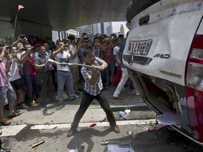 A protester destroys an overturned Japanese-brand police car with an metal rod during an anti-Japan protest in Shenzhen, Guangdong province, August 19, 2012. Foto: Keita Van / Reuters In English