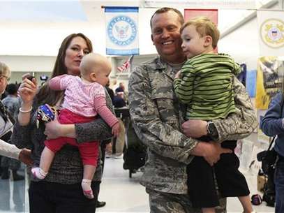 U.S. Air Force airman Lt. Col. Steven Vilpors walks with his wife Joanna and children Connor (R) and Alina (L) as he arrives in Baltimore Washington International Airport, Maryland December 20, 2011. Foto: Shannon Stapleton / Reuters In English