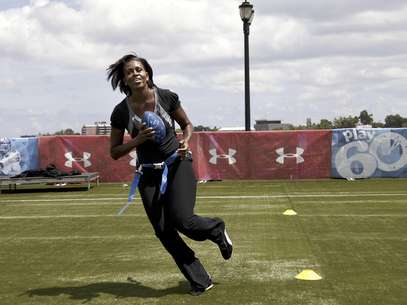 Michelle Obama corre con un ovoide de fútbol estadounidense como parte de las campañas Let's Move! y NFL's Play 60  en  Nueva Orleans en una fotografía del 8 de septiembre de 2010. La primera dama habló de su rutina de ejercicios con el sitio de internet iVillage.  Foto: Gerald Herbert, archivo / AP