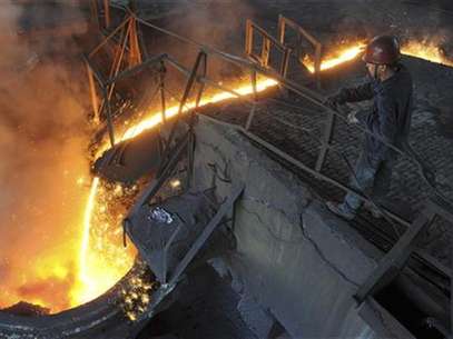 A worker monitors molten iron pouring into a furnace at steel manufacturing plant in Hefei, Anhui province August 15, 2012. Foto: Stringer / Reuters In English