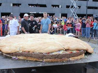 Una hamburguesa gigante con queso y tocino, de tres metros (10 pies) de diámetro y 914 kilogramos (2.014 libras) de peso, atrae la atención de numerosos curiosos momentos antes de que la sirvieran en el Casino-Hotel Black Bear cerca de Carlton, Minnesota. Foto: 
 / AP