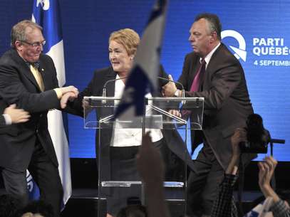 Pauline Marois, la líder del separatista Partido Quebequense, es sacada rápidamente del escenario por sus guardaespaldas mientras pronunciaba su discurso de victoria en Quebec, el martes 4 de septiembre de 2012. Con su triunfo electoral, Marois se convirtió en la primera mujer en alcanzar el cargo de premier de Quebec. La policía interrogó el miércoles a un hombre acusado de abrir fuego durante el mitin, en el que murió una persona.  Foto: Paul Chiasson, The Canadian Press / AP