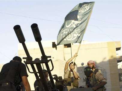 A member of the Free Syrian Army waves an Islamic flag during clashes with Syrian army forces in the Ghouta area of Damascus in this August 27, 2012 file photo. Foto: Files / Reuters In English