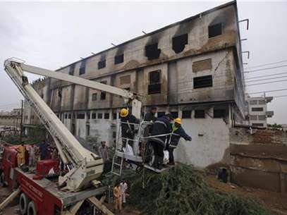 Un grupo de bomberos utilizan una escalera telescópica para retirar un cuerpo tras un incendio en una fábrica en Karachi, Pakistán, sep 12 2012. Al menos 314 personas murieron carbonizadas al incendiarse dos fábricas en Pakistán, dijeron el miércoles policías y funcionarios, en accidentes que abren interrogantes sobre la seguridad industrial de la nación del sur de Asia. Foto: Akhtar Soomro / Reuters en español