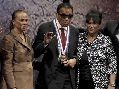 Boxing great Muhammad Ali waves after being awarded the Liberty Medal, as his wife Lonnie (L) and sister-in-law Marilyn Williams (R) look on, at the National Constitution Center in Philadelphia, Pennsylvania September 13, 2012. Ali, retired world heavyweight title holder, received the $100,000 award, sponsored by the nonprofit National Constitution Center, in recognition for his humanitarian efforts and work for civil rights at an awards ceremony on Thursday. Foto: Tim Shaffer / Reuters In English