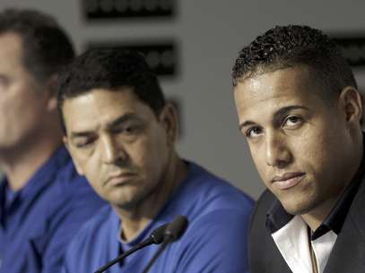El campocorto cubano Yunel Escobar, derecha, de los Azulejos de Toronto, se presenta acompañado por el mánager John Farrell, izquierda, y el entrenador Luis Rivera, centro, en conferencia de prensa antes del partido ante los Yanquis de Nueva York. Foto: Kathy Willens / AP