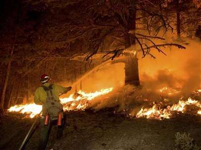 A firefighter sprays water during a burn operation in Boise National Forest near the community of Featherville, Idaho, in this U.S. Forest Service handout image dated August 22, 2012. Foto: Handout / Reuters In English