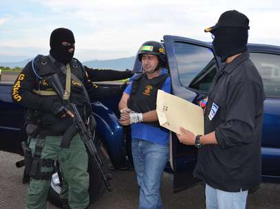 En esta foto difundida por el ministerio del Interior de Venezuela, agentes de la policía federal venezolana escoltan al capo narco Daniel Barrera, alias "El loco", al centro,hasta la base del comando regional nro 1 en San Cristóbal, estado de Táchira, Venezuela, el miércoles 19 de septiembre de 2012..  El presidente colombiano Juan Manuel Santos anunció el martes su detención en territorio venezolano.  Foto: Ministry of Popular Power for Interior Relations and Justice / AP