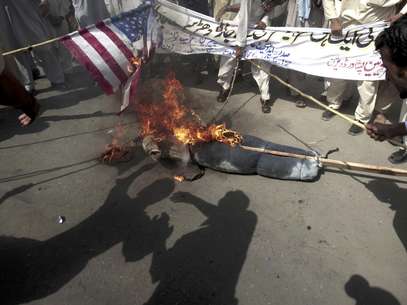 Manifestantes paquistaníes queman una bandera de Estados Unidos y una imagen del presidente estadounidense Barack Obama durante un mitin en Peshawar, Pakistán, como parte de la ira generalizada en el mundo musulman por una película hecha en territorio estadounidense que critica al profeta Mahoma, el jueves 20 de septiembre de 2012.  Foto: Mohammad Sajjad / AP