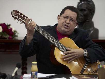 Venezuelan President Hugo Chavez plays a guitar, which was a gift from Mexican singer Vicente Fernandez, during a cabinet meeting at Miraflores Palace in Caracas September 20, 2012. Foto: Miraflores Palace / Reuters In English