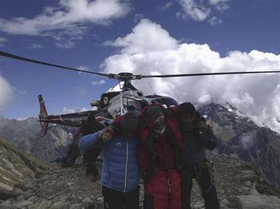 Rescue team members carry a tourist (C) after an avalanche at Mount Manaslu Base Camp September 23, 2012. Foto: Handout / Reuters In English