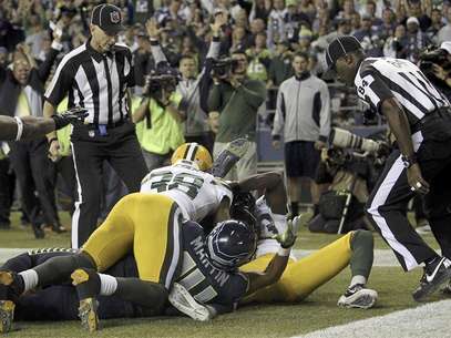 Referees wait to make the call on whether Seattle Seahawks wide receiver Golden Tate (bottom, obscured) caught the game winning touchdown against the Green Bay Packers in the fourth quarter of their NFL football game in Seattle, Washington, September 24, 2012. Tate should have been penalised on the game-ending play that denied the Green Bay Packers a win, the National Football League said on Tuesday while adding they will not overturn the result of the game. Seattle won Monday's game 14-12 after a last-sec Foto: Anthony Bolante / Reuters In English