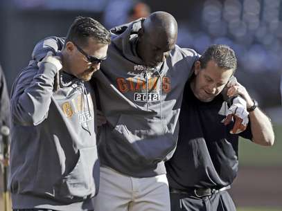 El coach de primera base de los Gigantes de San Francisco, Roberto Kelly, es sacado del terreno tras ser alcanzado por una bola bateada en una práctica el sábado 13 de octubre de 2012.  Foto: Mark Humphrey / AP