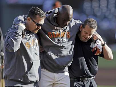 El coach de primera base de los Gigantes de San Francisco, Roberto Kelly, es sacado del terreno tras ser alcanzado por una bola bateada en una práctica el sábado 13 de octubre de 2012.  Foto: Mark Humphrey / AP