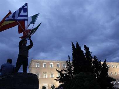 A protestor raises flags of Portugal, Italy, Greece and Spain in front of the parliament in Syntagma square during a 48-hour strike by the two major Greek workers unions in central Athens November 7, 2012. Foto: John Kolesidis / Reuters