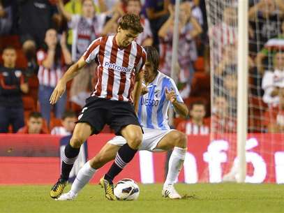 El delantero español del Athletic de Bilbao Fernando Llorente arrojó más dudas sobre su futuro al negarse a intervenir en una rueda de prensa del club el lunes. En la imagen, el jugador del Athletic de Bilbao Fernando Llorente (a la izquierda) y el jugador del Málaga Martin Demichelis luchan por el balón en su partido de Liga en el estadio de San Mamés en Bilbao, el 23 de septiembre de 2012. Foto: Félix Ordóñez / Reuters