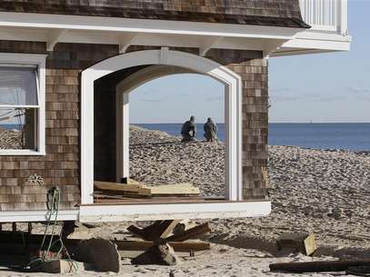 Two National Guardsmen, seen through empty window frames of a home, pause while on patrol at the beach front, to look at the ocean in the aftermath of Hurricane Sandy, at Bay Head, New Jersey November 4, 2012. Foto: Tom Mihalek / Reuters