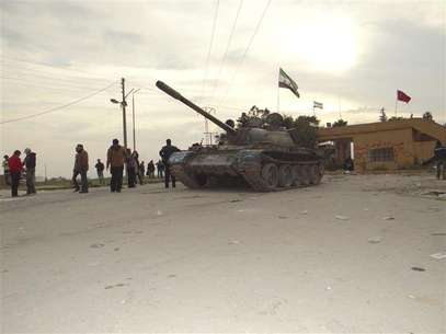 Residents and Free Syrian Army fighters pose near a tank after the fighters said they fought and defeated government troops from the town of Ras al-Ain, near the province of Hasaka, 600 km (375 miles) from Damascus, November 22, 2012. Foto: Samer Abdullah / Reuters