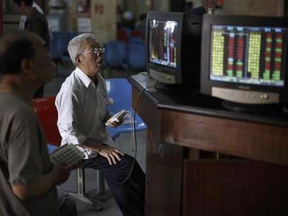 Investors look at computer screens showing stock information at a brokerage house in Shanghai in this June 8, 2012 file photo. Foreign investors have started rebuilding their China equity portfolios, tempted by low valuations after two years of market underperformance and signs economic growth may be stabilizing. They have pumped nearly $4 billion (2 billion pounds) into Chinese equity funds in the past two months alone, trying to get in early on what they hope will be a sustained rally. Picture taken June 8, 2012. Foto: Aly Song / Reuters