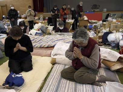 Victims of the March 11 earthquake and tsunami observe a minute of silence at a shelter in Kamaishi, Iwate prefecture, in this April 11, 2011 file photograph, marking the one month anniversary of the deadly quake which triggered the tsunami and nuclear crisis in Japan. Weeks before Japan's first national election on December 16, 2012, since the earthquake, none of the contenders has managed to win the hearts, and votes, of those hardest-hit by the disaster - with many feeling let down by the entire political class. Volunteers and donations had poured in after the magnitude 9.0 quake off the northeast coast of Japan's main island Honshu unleashed a deadly tsunami that killed nearly 19,000 and triggered reactor meltdowns at the Fukushima nuclear plant. But 20 months later, residents of towns and cities ravaged by the country's worst disaster in generations say the nation's biggest rebuilding effort since the aftermath of the World War Two has slipped off the political agenda. Foto: Toru Hanai / Reuters