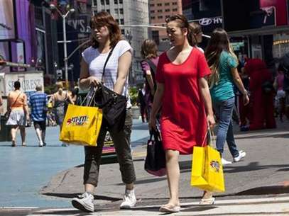 Women carry shopping bags through Times Square in New York, July 27, 2012. Foto: Andrew Burton / Reuters
