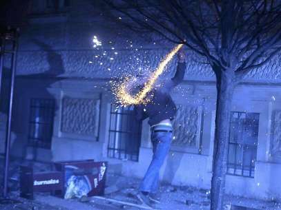 A protester throws fireworks during clashes in Maribor December 3, 2012. Protesters clashed with police in Slovenia's second largest city Maribor on Monday in a demonstration against budget cuts in the financially troubled Alpine state. Police said more than 20 people were arrested in Maribor and at least one policeman was injured after some from a crowd of around 6,000 protesters threw firecrackers, fireworks and rocks. Foto: Srdjan Zivulovic / Reuters
