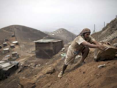 En esta fotografía del 26 de noviembre de 2012, se ve a Jaime Arévalo mover una piedra trabajando para reconstruir su nueva casa, una chabola en la cima del monte Nueva Rinconada, en las afueras de Lima, Perú. Sismólogos, ingenieros y funcionarios de defensa civil acordaron que Lima es vulnerable en caso de un terremoto y no está preparado. Además de lugares sensibles a un maremoto, como el Callao, hay sitios como Nueva Rinconada, que es refugio de gente que llega de todo el país a la capital peruana como refugiados económicos y viven en hogares precarios situados en lugares propensos a deslaves y derrumbes.  Foto: Rodrigo Abd / AP
