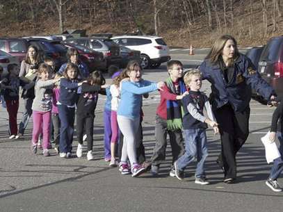 En esta foto proporcionada por el diario Newtown Bee, la policía de Connecticut aleja a los niños de la Escuela Primaria de Sandy Hook en Newtown Connecticut, tras un ataque a tiros dentro de la institución, el vienres 14 de diciembre de 2012   Foto: Newtown Bee, Shannon Hicks)  MANDATORY CREDI / AP